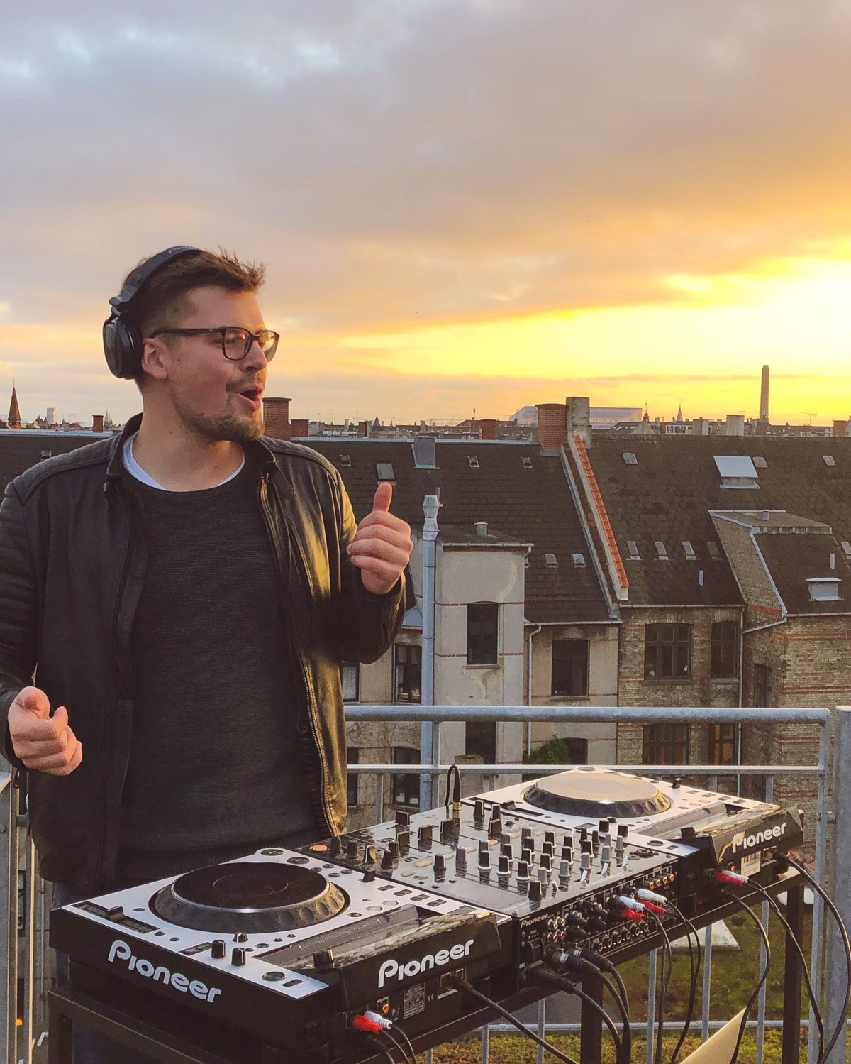 Woodworks DJing on a rooftop at golden hour